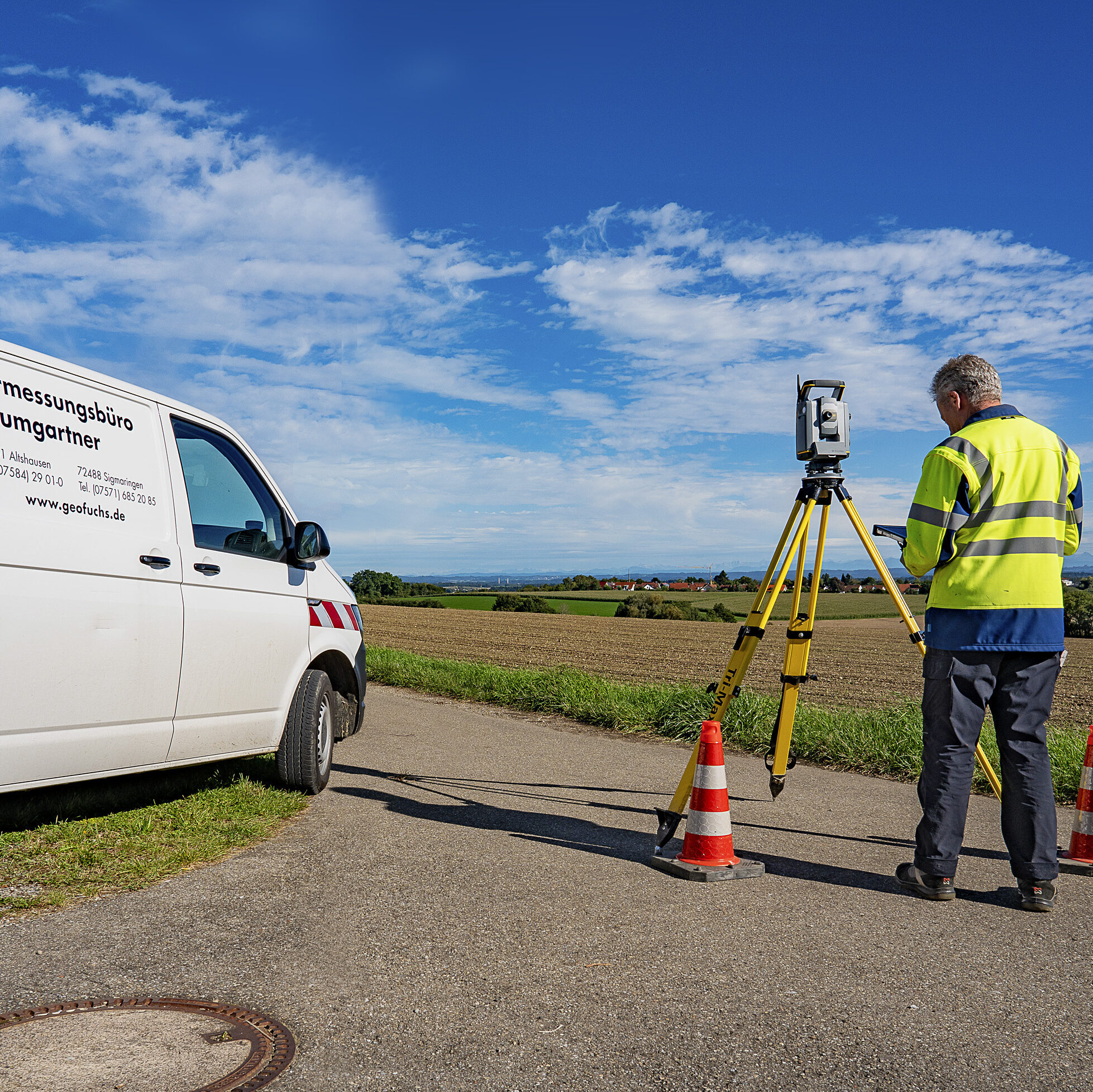 Auto und Mann der gerade eine Vermessung vornimmt